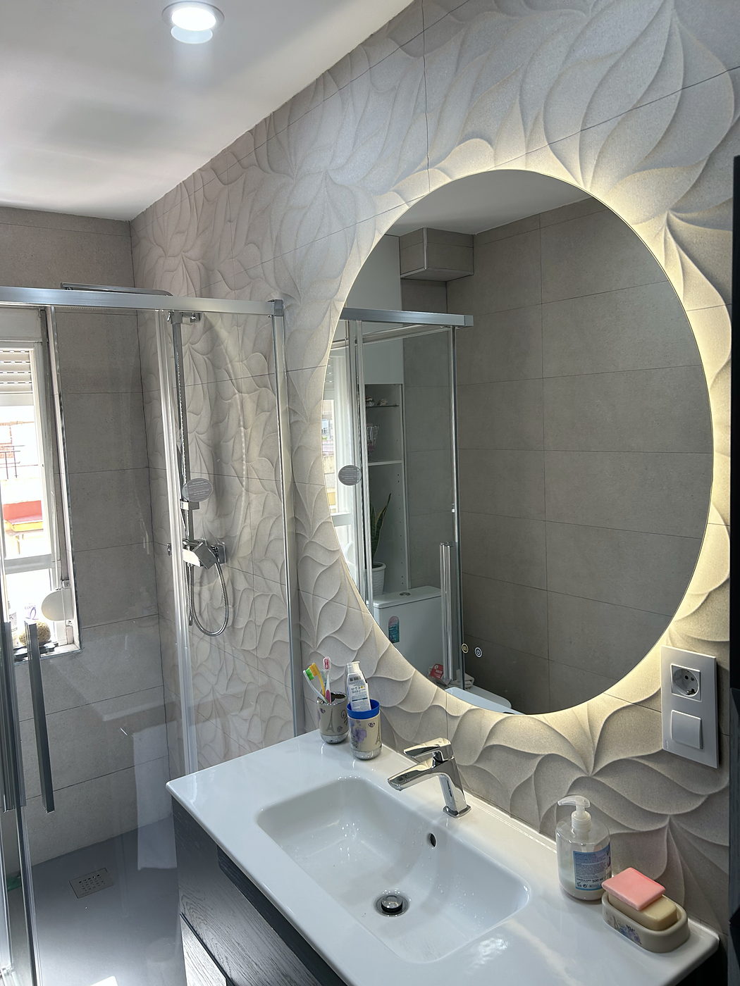 Baño reformado en Sevilla con espejo retroiluminado y mueble suspendido