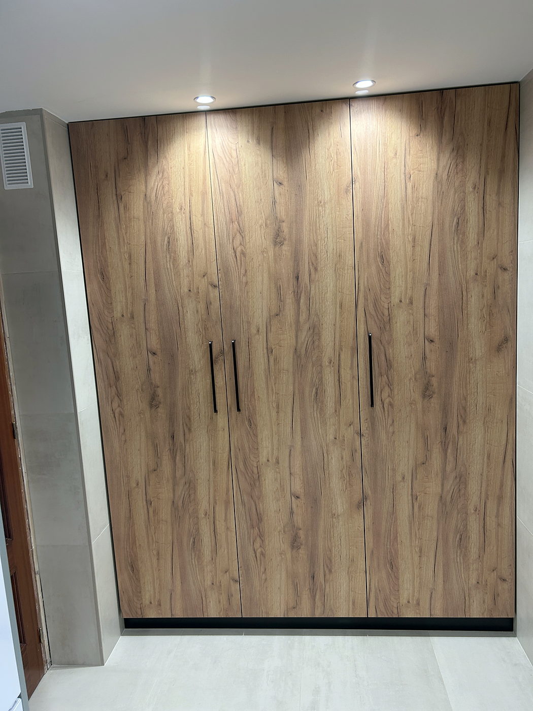 Columna de despensa en roble con iluminación LED en cocina reformada en Sevilla