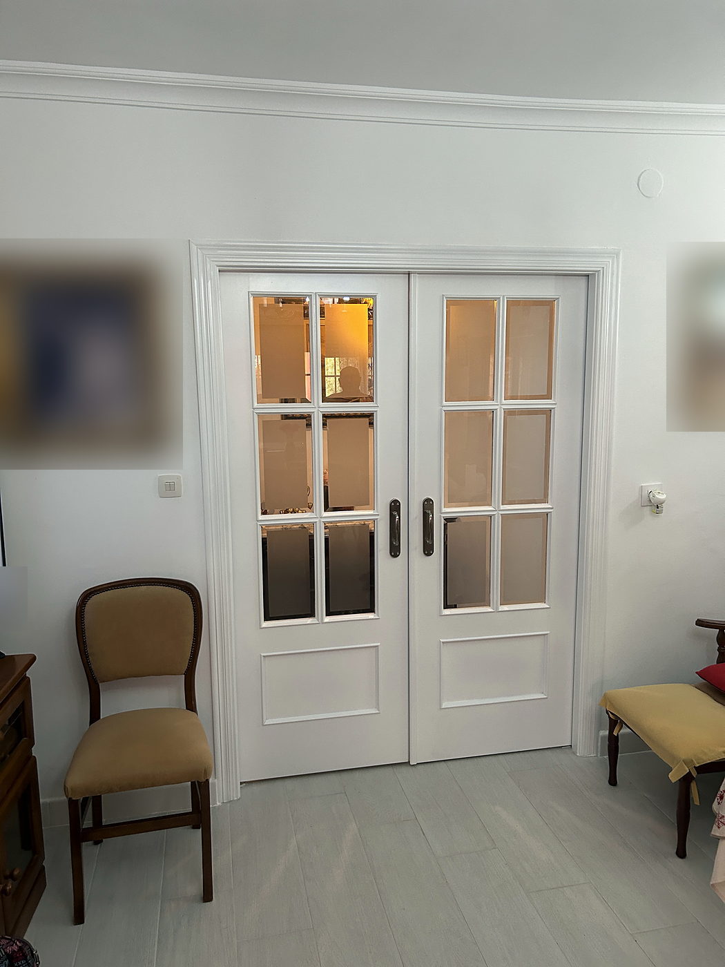Salón con puertas acristaladas y suelo continuo tras una reforma integral en Sevilla